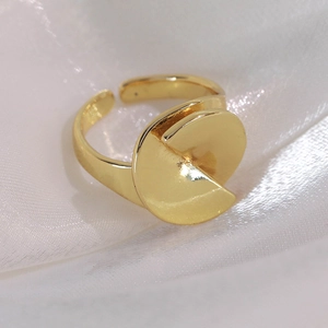 Close-up of geometric layered gold ring on elegant white silk fabric background