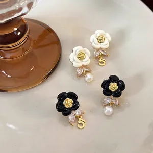 French vintage enamel camellia earrings with pearls and zircon in a ceramic dish