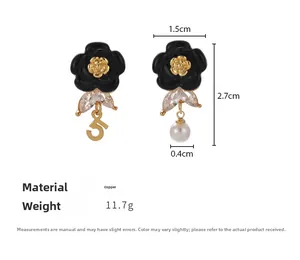 Detail of camellia earrings with black petals, pearl drops, and gold number five detail