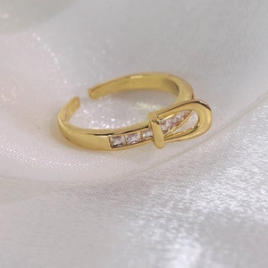 Vue macro d'une bague boucle de ceinture dorée avec zircons carrés et anneau ouvert