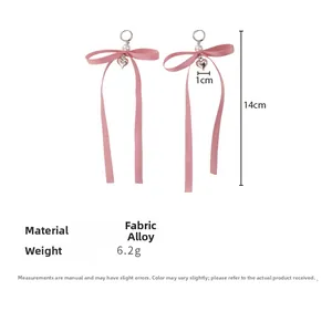 Dettaglio orecchini a fiocco rosa da 14cm con perla bianca e ciondolo a cuore argento