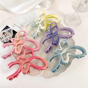 Pinces à cheveux papillon aux dégradés de couleurs vives sur un plateau blanc élégant