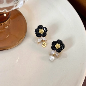 Detailed shot of French style enamel camellia earrings with pearl and zircon charms