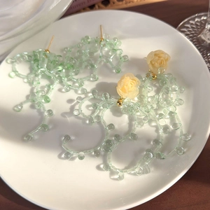Boucles d'oreilles pompon vert menthe avec rose en résine crème et liens dorés
