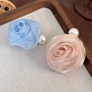 Détail de pinces à cheveux roses en maille bleu clair et rose avec perles en nacre
