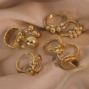 Minimalist gold geometric stackable rings set with polished spheres on satin fabric