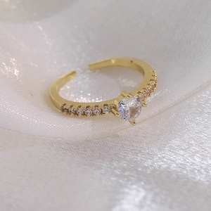 Détail macro d'une bague papillon dorée avec sertissage à quatre griffes et oxydes