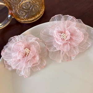 Close-up of pink mesh flower earrings with delicate petal layering and bead stamens