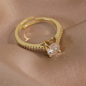 Vue macro d'une bague papillon dorée avec zircon rond serti griffes et micro-pavage