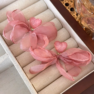 Close-up of pink mesh floral earrings with a glittery heart center in a velvet box