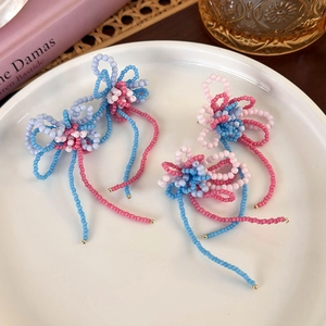 French vintage handmade beaded flower tassel earrings in pastel colors on a ceramic tray