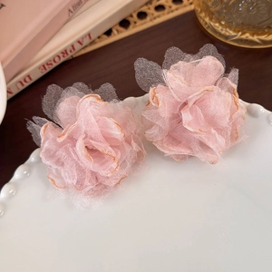Detailed close-up of pink organza flower earrings with delicate scorched edge design