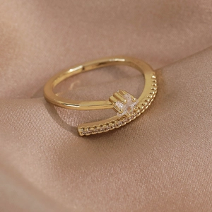 Détail de la bague papillon dorée avec zircon sur un tissu en soie de couleur champagne