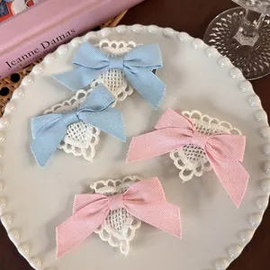 Sweet heart lace bow hair clips in pink and blue on a decorative white porcelain plate