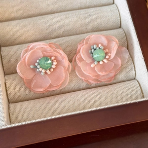 Macro shot of pink layered mesh flower earrings with crystal center and bead details
