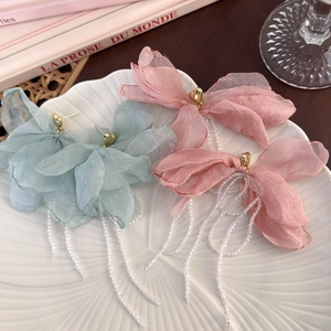 Detail of elegant heart studs with layered fabric petals and long crystal bead tassels