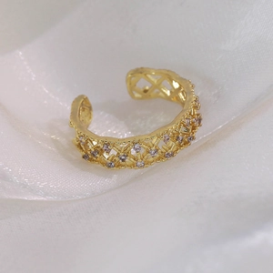 Gros plan d'une bague dorée maillée avec zircon violet serti sur fond de soie