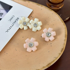 Boucles d'oreilles fleuries élégantes avec émail crème et cristaux centraux brillants