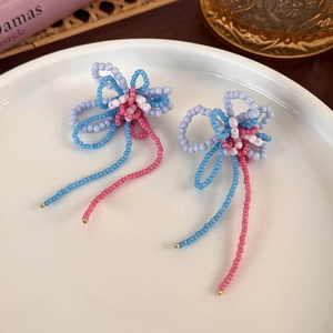 Detailed macro shot of handmade beaded butterfly earrings with colorful fringes