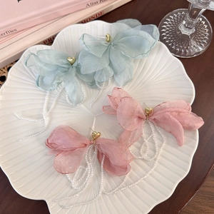 Detail of pink and blue chiffon bow earrings with gold hearts and beaded tassels