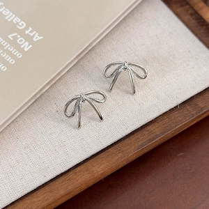 Elegant silver bow stud earrings with polished metal finish and artistic minimalist design