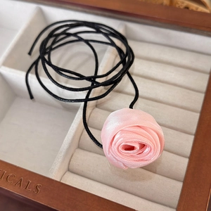 Detailed close-up of handmade pink satin rose choker with elegant layered petals