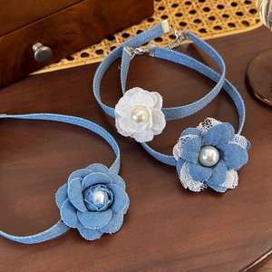 Three-piece denim and lace flower choker set with pearl centers on a vintage wooden tray