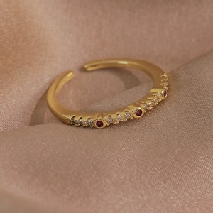 Macro d'une bague papillon plaqué or avec zircons rouges sur fond de tissu en soie