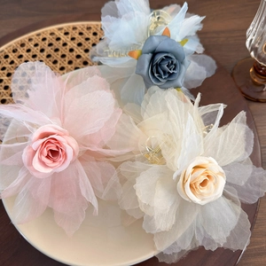 Tre eleganti fermagli per capelli con rose in rete rosa, blu e bianche su legno