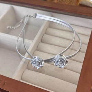 Detail view of double-layered silver rose necklace with lobster clasp and extension chain
