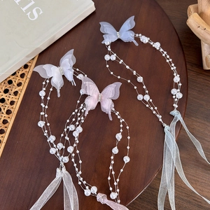 Detailed macro view of butterfly pearl tassels with sheer ribbons in three colors