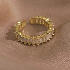 Gros plan d'une bague papillon dorée avec zircons sur un tissu en soie champagne