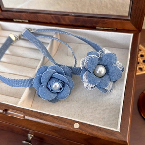 Detail of denim lace flower choker with pearls inside a vintage wooden jewelry box