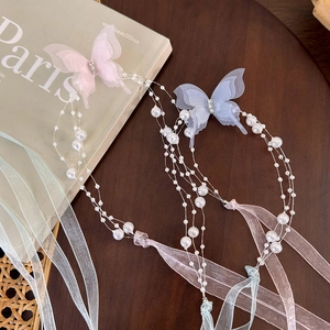 Close-up of elegant butterfly pearl hair accessories with delicate organza ribbons
