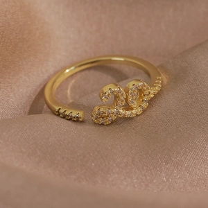 Détail macro d'une bague ouverte dorée avec un motif 2023 serti de zircons scintillants