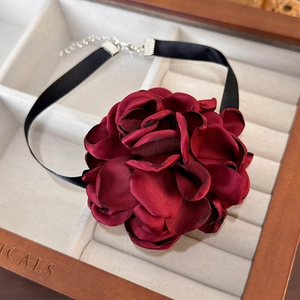 Detailed view of handmade deep red satin flower choker necklace in a wooden jewelry box