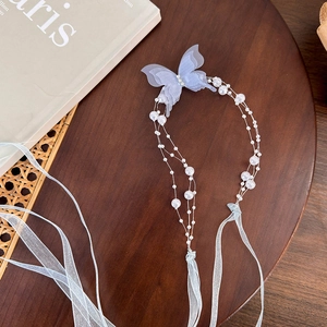 Detail of light blue butterfly pendant with pearl chain and elegant organza ribbons