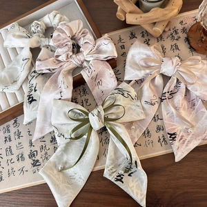 Détail de chouchous en soie avec calligraphie chinoise et pendentifs en perles