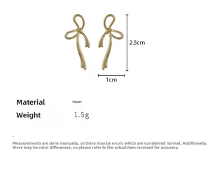 Detail view of golden ribbon bow earrings in copper with dimensions 2.5x1cm and 1.5g weight