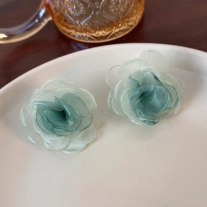 Close-up of mint green tulle flower earrings with delicate multi-layered mesh petals
