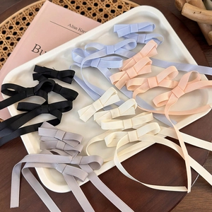 Detailed view of ballet style ribbon bow hair clips in assorted Morandi colors