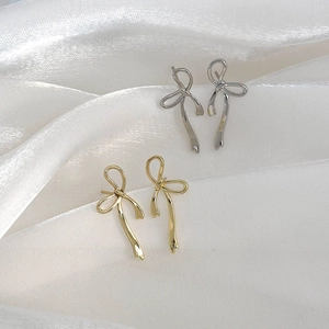 Minimalist ribbon bow stud earrings in gold and silver finish on white silk