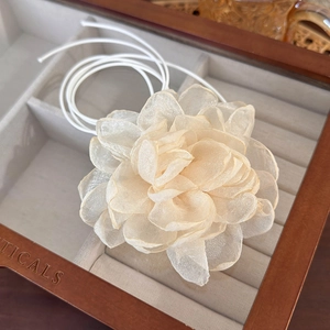 Macro shot of camellia-shaped organza choker flower with elegant layered petal detail