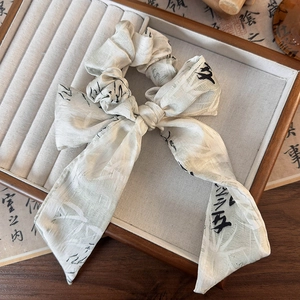 Détail d'un chouchou en soie beige avec calligraphie chinoise et imprimé bambou sur plateau