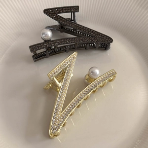 Pinces à cheveux élégantes lettre V en or et bronze avec perles et cristaux dans un plat