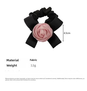 Dettaglio di un elastico per capelli con rosa in tessuto da 4,5cm e fiocco nero