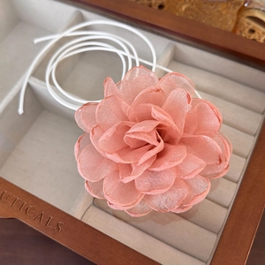 Detail of handmade salmon pink organza flower choker in a wooden jewelry gift box