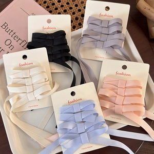 Detail of five-color ribbon bow hair clips set on display cards for ballet style