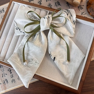 Détail d'un chouchou imprimé bambou à l'encre avec ruban olive et accents de perles