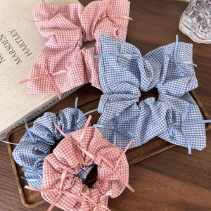 Detail of checkered ballet style bow scrunchies in pink and blue cotton fabric set